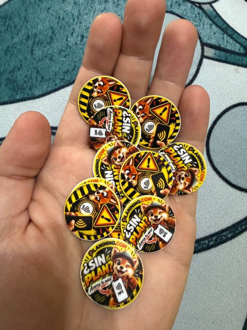 Pegatinas NFC redondas impresas con los diseños de Planining, en la palma de una mano